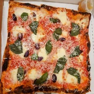 a pizza in a box with cheese and spinach