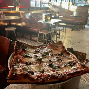 a pizza in a pan on a table in a restaurant