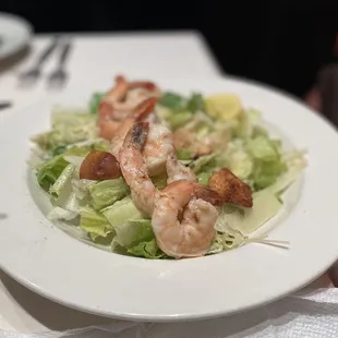 a plate of salad with shrimp and lettuce