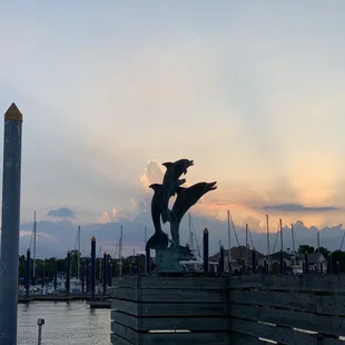 a statue of two dolphins on a dock