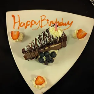 a piece of chocolate cake with strawberries and blueberries