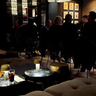 a group of people sitting at tables in a dimly lit room