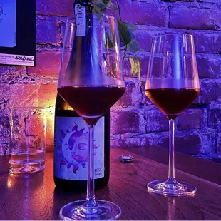 wo glasses of wine and a bottle of wine