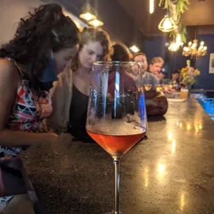  glass of wine sitting on a bar