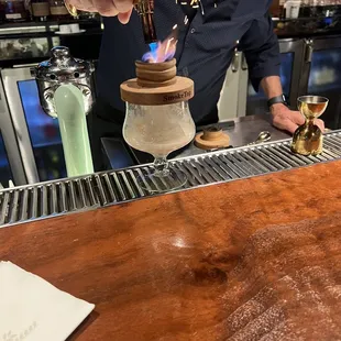 a bartender making a drink at a bar