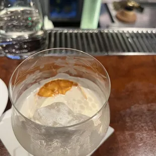 a glass of water with ice and a slice of orange