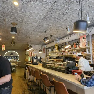 a man standing at a counter in a restaurant