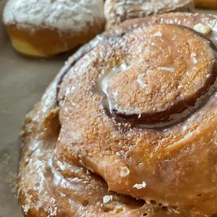 Cinnamon roll and assorted donuts in the back