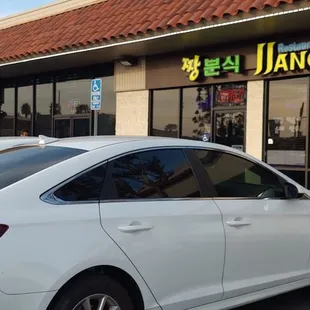 a white car parked in front of a restaurant
