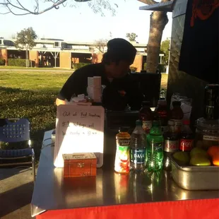 a man standing at a table with a sign on it