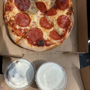 a pepperoni pizza and two drinks