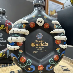 a black bottle with skulls and flowers