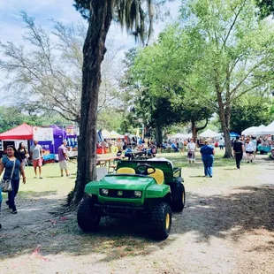  green tractor parked under a tree