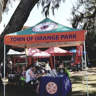 people sitting at a table under a tent