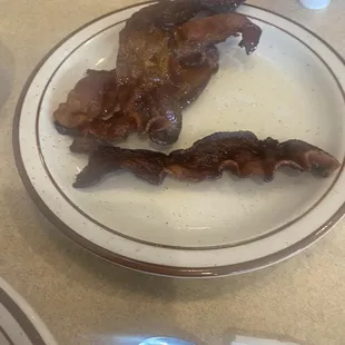 a plate of bacon and a spoon