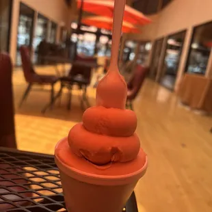 a cup of ice cream with a spoon sticking out of it