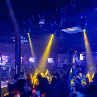 a large group of people dancing in a nightclub