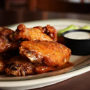 a plate of chicken wings with dipping sauce