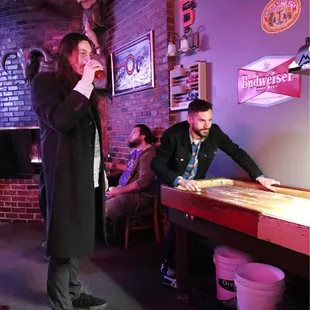 Anthony Bianconi drinking beer and Greggy playing shuffleboard in their favorite Orchid Room.