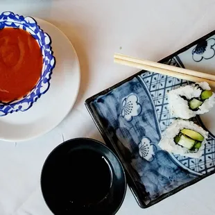 a plate of sushi and a bowl of sauce