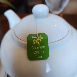 a teapot with a green tea tag