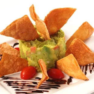 a plate of guacamole and tortillas