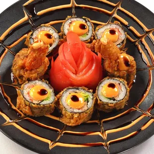 a plate of sushi rolls and a tomato