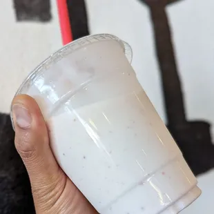 a hand holding a cup of yogurt