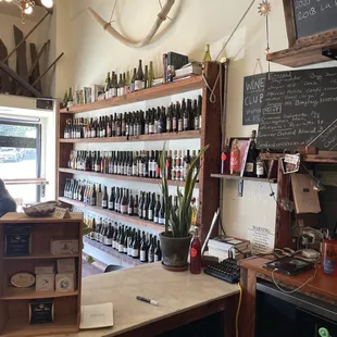 a man at a counter in a wine shop