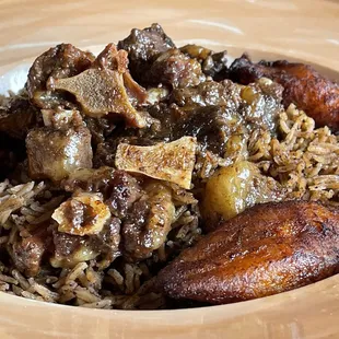 Oxtail - daily special.  Over Haitian rice.  He didn&apos;t leave even a grain of rice in the dish :)