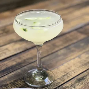 a cocktail in a coupe glass on a wooden table