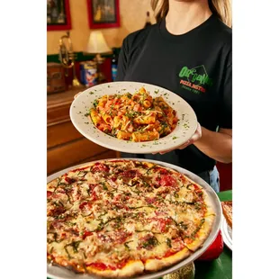 a woman holding a plate of pizza