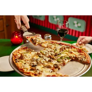 a person cutting a pizza