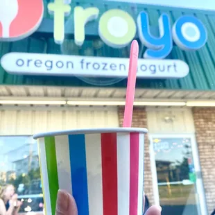 a person holding a cup of yogurt