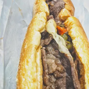 What&apos;s you are viewing is a very authentic Cheesesteak with a delicious roll . It is provolone wit, and has roasted long hots on it