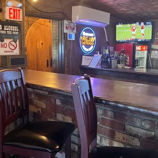 a bar with chairs and a television