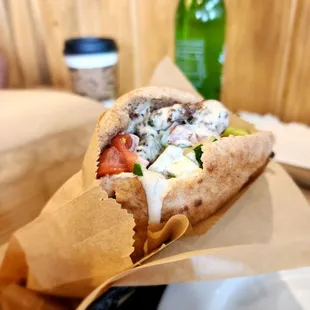 a pita sandwich in a paper wrap