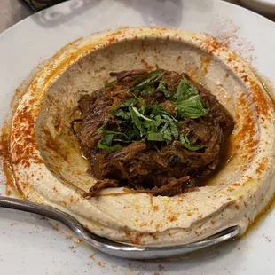 Pomegranate lamb hummus plate, lamb flavor did not impress and notice its proportion to the spoon.