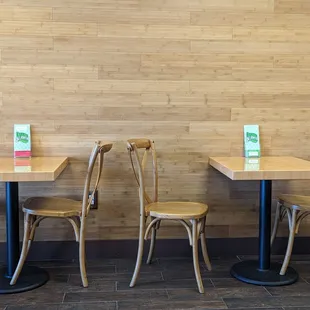 tables and chairs in front of a wood paneled wall