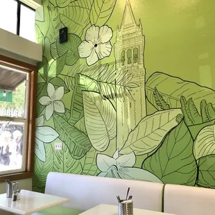 a green wall with a church in the background