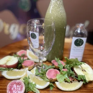 a table with a bottle of juice and sliced fruit