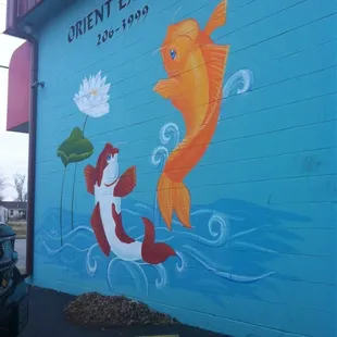 a mural of a fish and a lotus flower