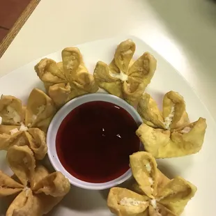 a plate of wontons with dipping sauce