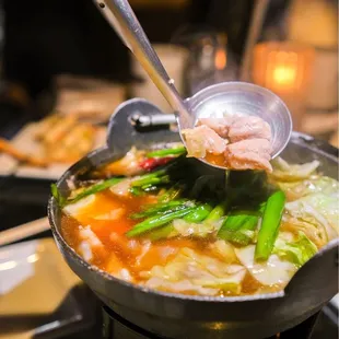 a bowl of soup with chopsticks