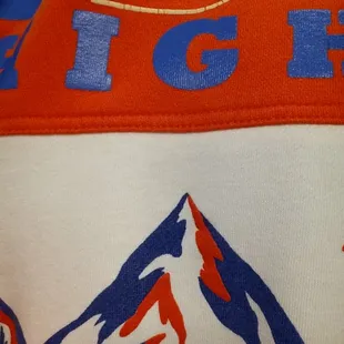 a closeup of a hat with a mountain in the background