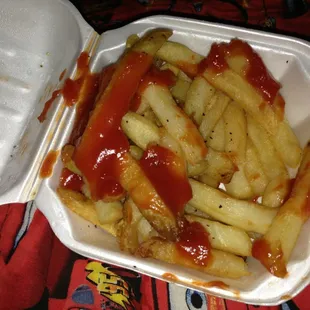 french fries and ketchup in a styrofoam container
