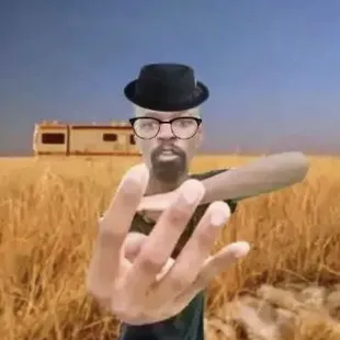 a man holding a knife in front of a wheat field