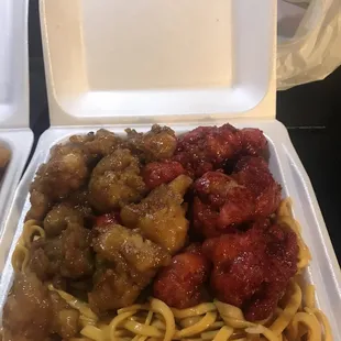 a takeout box with noodles and meatballs