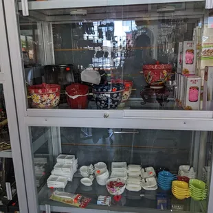 a display case with dishes and cups