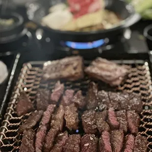 steaks cooking on a grill